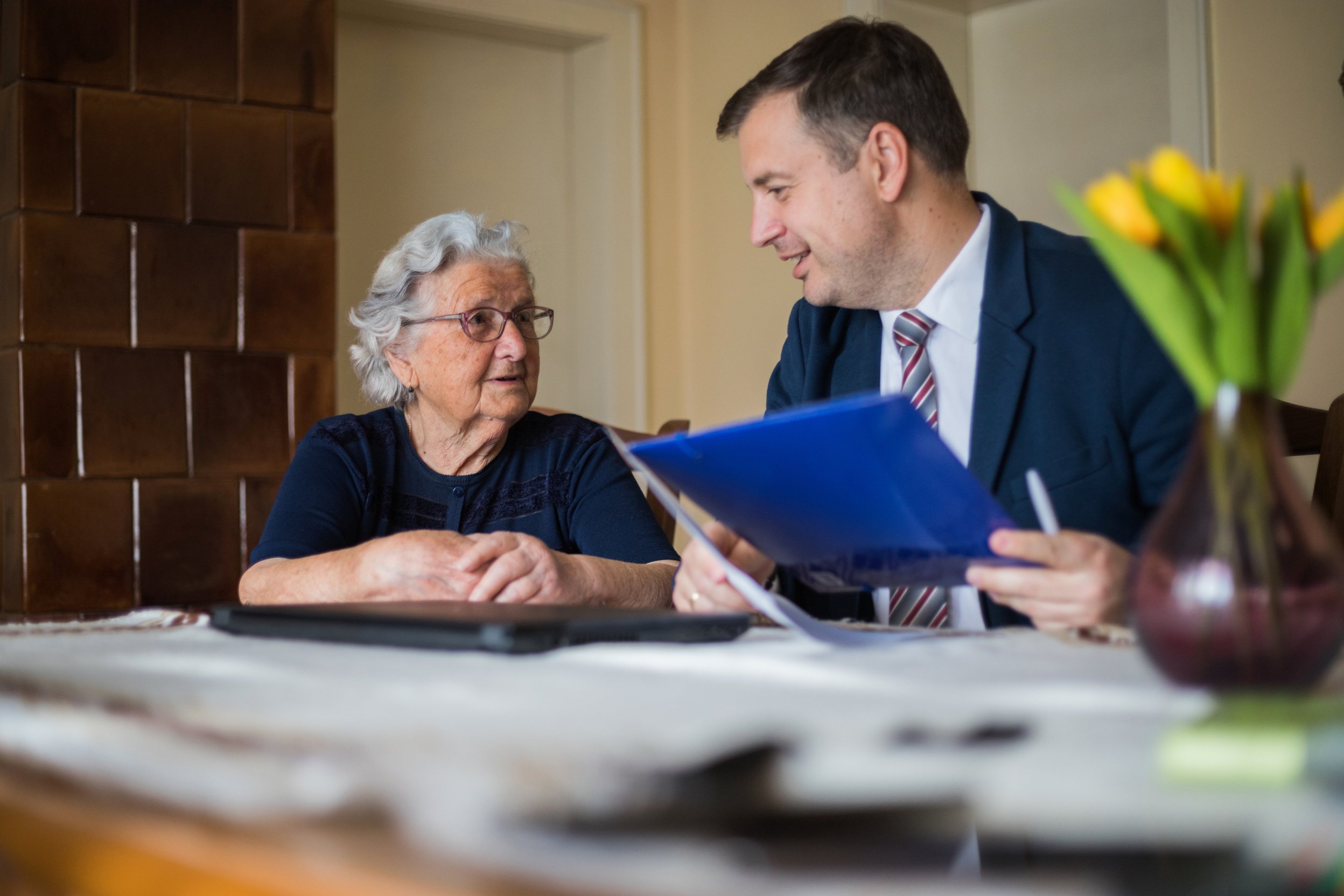 Lawyer bringing contracts to elderly client